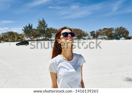 Woman in sunglasses white T-shirt sand palm island                  