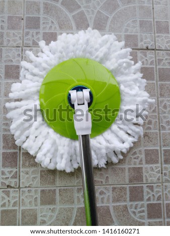 White mop with a green handle And beautiful background