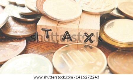 Wooden Text Block of Tax and Pile of Coins