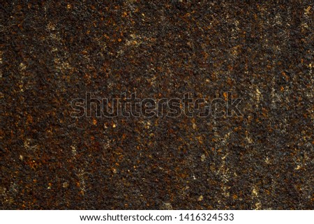 Rusty surface of metal wall with black, brown and yellow texture.