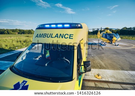 Ambulance car against helicopter of emergency medical service. Themes rescue, help and hope.
