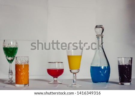 glasses of different shapes filled with colored liquid