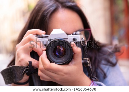 Young woman taking pictures with analog camera