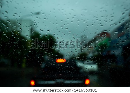 Rain drops on the pane of glass with traffic jam background