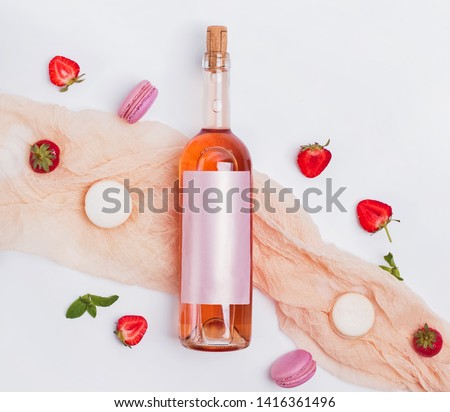 Rose wine, strawberries and french dessert macarons on the white background, top view. Creative summer composition Royalty-Free Stock Photo #1416361496