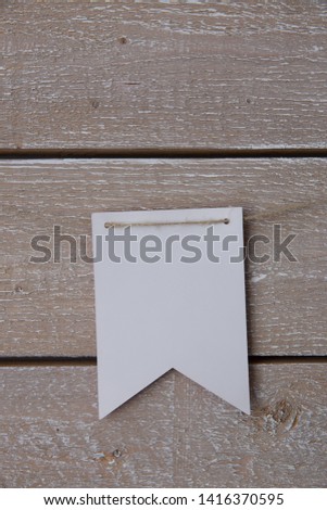 White paper flags handing on wooden background.