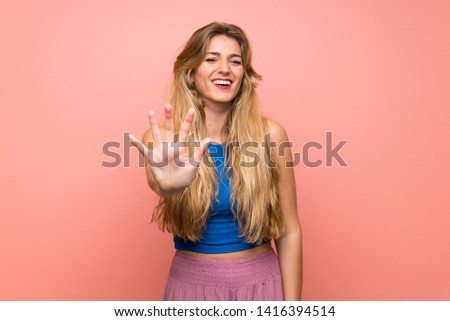 Young blonde woman over isolated pink background counting five with fingers