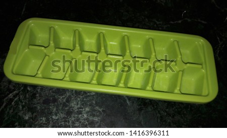 green ice tray on dark background 