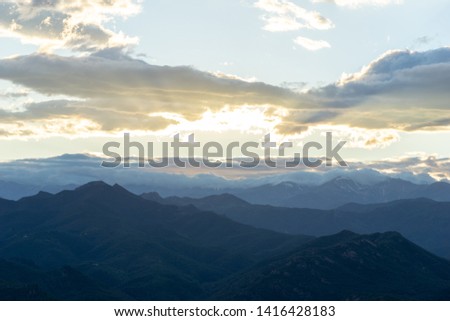 Mediterranean landscape, forest mountains and a screen in the lower part, with sun rays illuminating the image, feeling calm