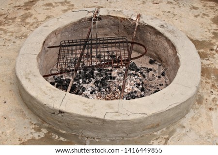 A cement fire pit which is used to cook meat (braai).