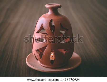 Picture of a clay candle holder sitting on a table 