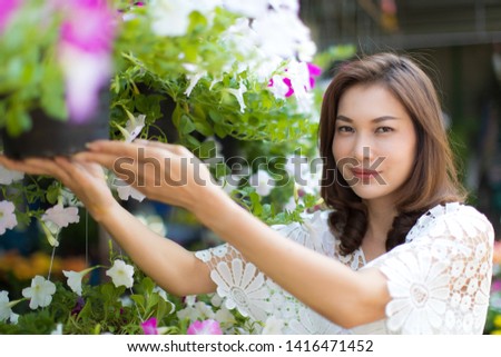 Beautiful Asian woman selecting flower in floral shop, lifestyle of modern housewife.
