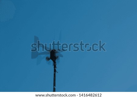 Picture of a weathervane  taken on  multiple exposures showing the changing direction of the wind.  Can also be associate with politicians and how some people change their mind all the time.
