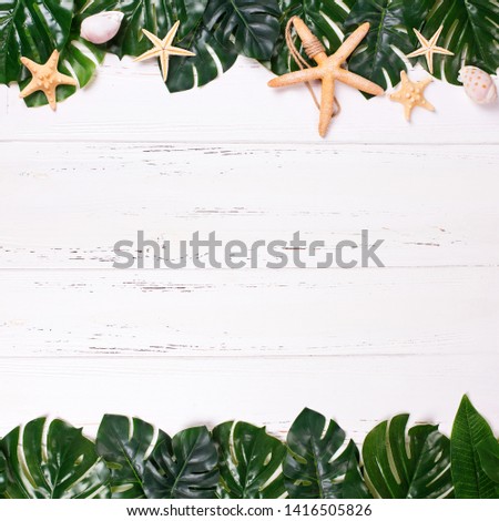 Summer vacation concept. Border or frame from tropical leaves  and ocean treasures on  white textured background. Flat lay. Place for text.
