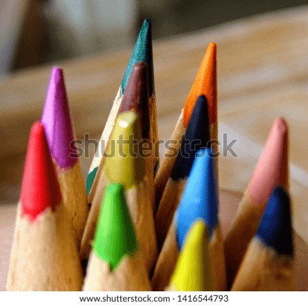 Colorful crayons for painting laid on a wooden board, school supplies
