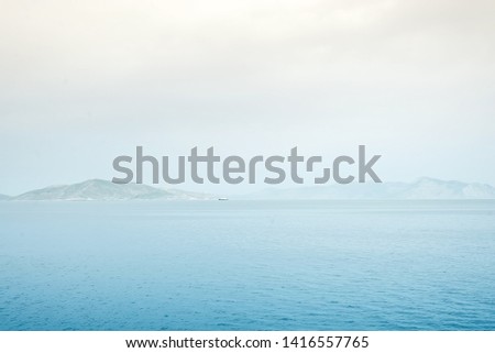Foggy mountain misty islands covered with fog, calm sea lake landscape background, sunlight in cloudy sky scenery morning weather, Royalty-Free Stock Photo #1416557765