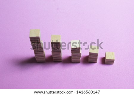 The wooden surface cube is stacked together in layers on pink background