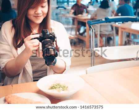 woman power with hobby and lifestyle  concept from beauty woman photographer’s hand hold camera and take photo to morning food in restaurant with copy space background