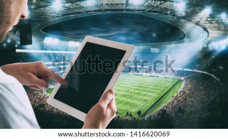 Man with tablet at the stadium to bet on the game Royalty-Free Stock Photo #1416620069