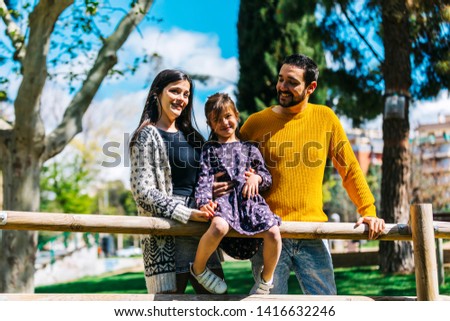 Happy family in the park. Father mother and son together in nature look at the camera
