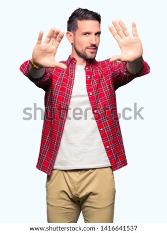 Handsome man wearing casual shirt Smiling doing frame using hands palms and fingers, camera perspective