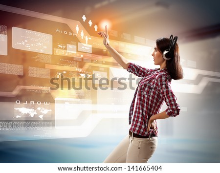 Image of young woman with headphones touching virtual screen