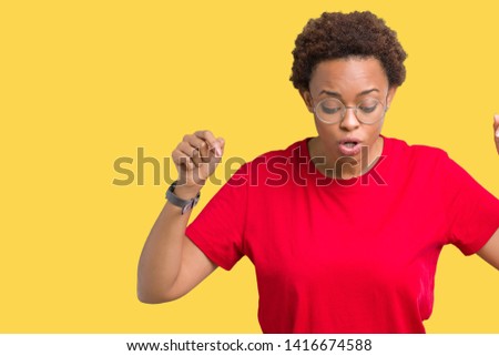 Beautiful young african american woman wearing glasses over isolated background Pointing down with fingers showing advertisement, surprised face and open mouth