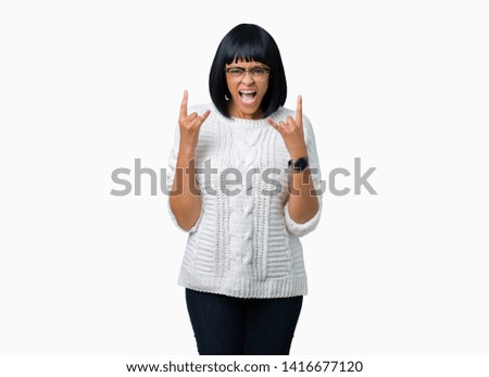 Beautiful young african american woman wearing glasses over isolated background shouting with crazy expression doing rock symbol with hands up. Music star. Heavy concept.