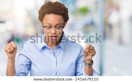 Young beautiful african american business woman over isolated background Pointing down with fingers showing advertisement, surprised face and open mouth