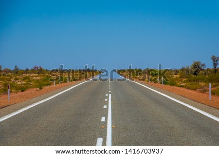 Mirage over straight endless road in Australia merging asphalt and sky