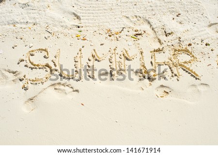 inscription "summer" on white sand of tropical beach