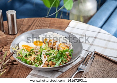 Close up view on turkey salad with chickpeas served in bowl on wooden table. Healthy food, dieting. Copy space for design. Picture for recipe, menu.