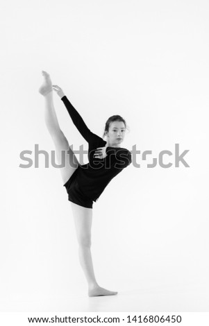 
girl dancer. girl in black sports uniform is training in the white spacious hall