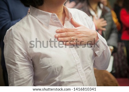 a woman standing with her hand to her chest during a coaching session