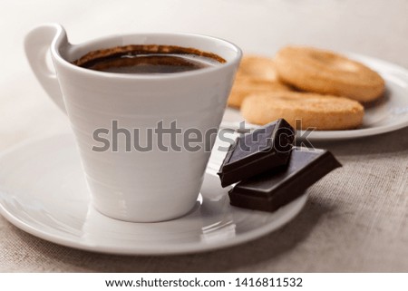 Coffee in a cup, chocolate and cookies on a saucer