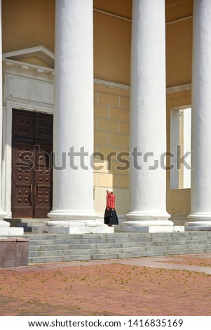 A lonely parishioner walks to the door of an Orthodox church, a beautiful majestic architectural structure.