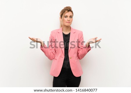 Young blonde woman with pink suit making doubts gesture