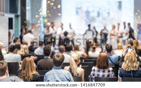 Young business team receiving award prize at best business project competition event. Business and entrepreneurship award ceremony theme. Focus on unrecognizable people in audience. Royalty-Free Stock Photo #1416847709