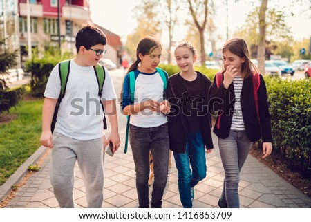 Group of schoolmates going home after school on sunny day and having fun Royalty-Free Stock Photo #1416853709
