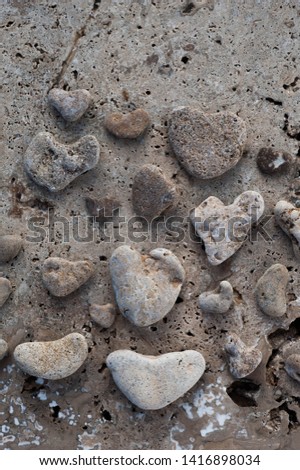 Sea Stone Hearts. Beach pebble heart shaped stone collection photograped on tectural stone. 