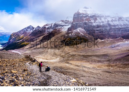 Senior women hiking and falling on the moraines of the Victoria Glacier from the Plain of Six Glaciers Teahouse to the to the Six Glaciers at Lake Louise in Banff National Park, Alberta, Canada