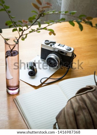 Vintage film cameras, film cartridges with stationery on wooden floors.