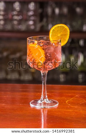 Apperol shpritz cocktail with orange slice and ice cubes.