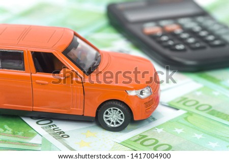 orange car and money, euro and dollars. insurance concept