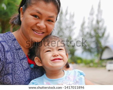 Beautiful Asian, Thai, mother enjoyed being with her little baby girl, two years old - mom and daughter bond