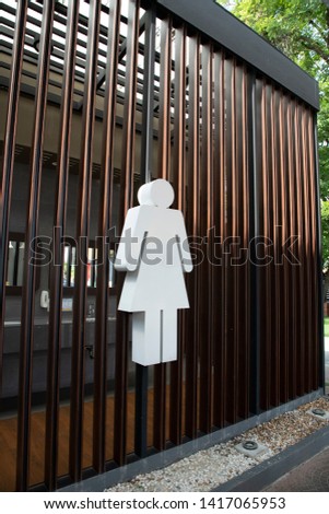 Sign restroom women on wood battens.