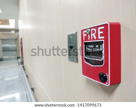 Fire alarm switch on the white wall.
