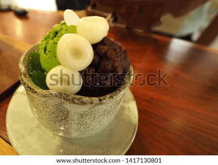 Mochi , green tea ice-cream ,  and red bean  in cup on wood table