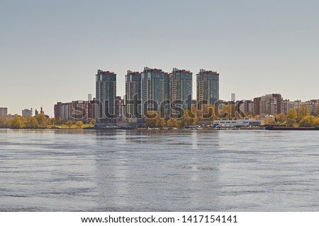 High-rise modern buildings on the embankment of the river during the day. Cityscape against the blue sky