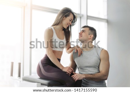 Athlete couple smiling after good workout in gym. Sporty Gym Concept